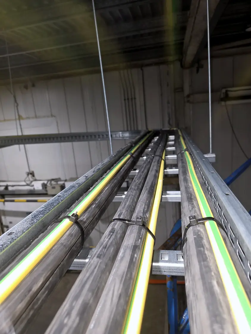 Large AC cables with green/yellow earths cleated on ladder rack