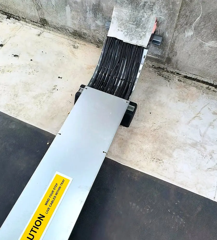 Lidded cable tray on the roof, with a caution label